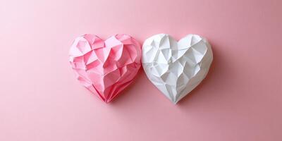 Colorful pink and white origami hearts placed side by side on a smooth pink background photo