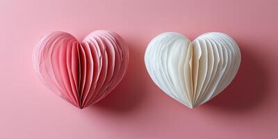 Crafted paper hearts in soft pink and white colors on a light pink background perfect for celebrations or decorative purposes photo