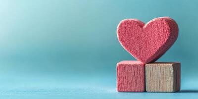 Heart-shaped block rests atop two wooden cubes on a blue background, symbolizing love and affection in a minimalist style photo