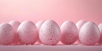 Colorful speckled eggs arranged in a row on soft pink background with sugar crystals scattered around photo