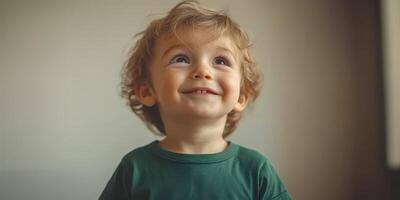 Child with curly hair smiling joyfully while looking upwards indoors during bright daylight photo