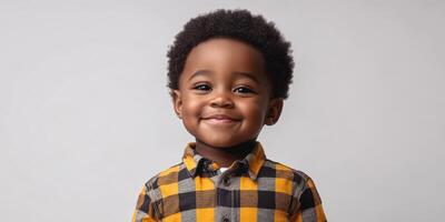 Young boy with joyful smile wearing checkered shirt in studio setting during daylight photo