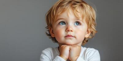 Curious young child gazes upward with thoughtful expression in a soft-lit indoor space photo