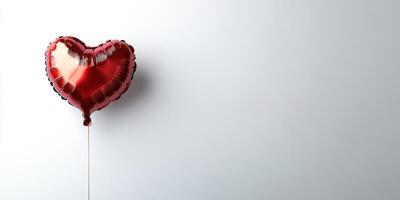 Heart-shaped red balloon floating against a minimalistic white background celebrating love and affection on a joyful occasion photo