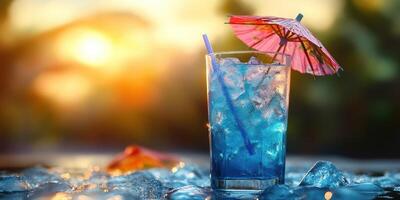 Refreshing blue cocktail served in a glass with a colorful umbrella during a summer sunset at a beach setting photo