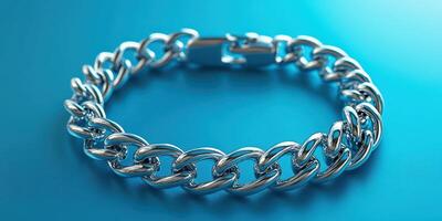 Silver chain bracelet resting on a blue surface showcasing its shiny and intricate link design photo
