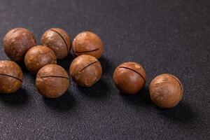 Macadamia nuts displayed on a dark background, ready for snacking photo