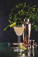 Refreshing cocktail with lime and copper bar tools on wet bar top photo