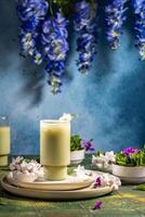 Refreshing iced matcha latte garnished with a delicate flower and mint leaf, served on a stylish table setting photo