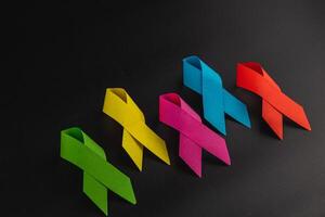 Ribbons representing various cancer awareness campaigns on a dark surface photo