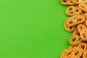crujiente pretzels dispersado en un vibrante verde antecedentes para merienda foto
