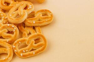 crujiente pretzels dispersado en un ligero antecedentes con sésamo semillas foto