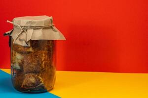 Homemade preserved meats in jar with colorful background photo