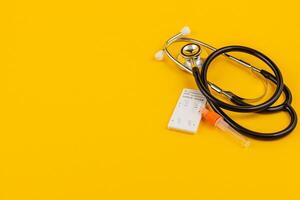 Stethoscope and supplies on bright yellow for health awareness photo