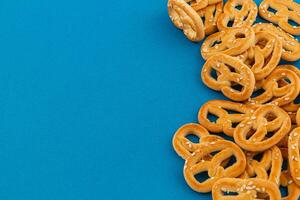 recién horneado pretzels dispersado en un azul antecedentes foto