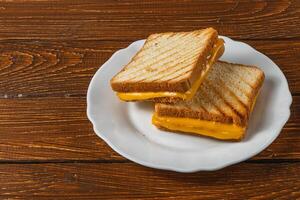 Delicious grilled cheese sandwich served on a white plate for brunch photo