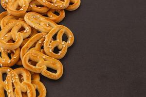 delicioso pretzels con sésamo semillas arreglado en un oscuro antecedentes foto