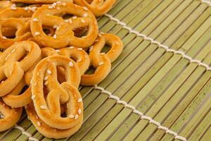 recién horneado pretzels en un bambú estera con un toque de sésamo semillas foto