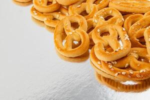 deliciosamente horneado pretzels con sésamo semillas en un reflexivo superficie foto