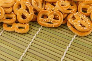 mini pretzels rociado con sésamo semillas arreglado en bambú estera foto