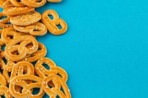 sabroso pretzels dispersado en un vibrante azul superficie para un vistoso bocadillo foto