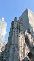 New York City, USA, August 14, 2024. The gothic St. thomas church in vertical format footage. It is striking in comparison with the modern skyscrapers that surround it. Beautiful summer day. video