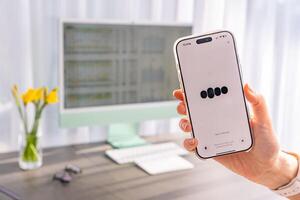 Prague, Czech republic - February 24, 2025. Close up view of hand holding Iphone with Chat Gpt application on screen. Work assistant with Open Ai. Artificial Intelligence concept. High quality photo
