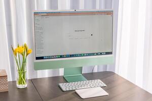 Prague, Czech republic - February 24, 2025. Work place with iMac with open Chat Gpt application on screen. Work assistant with Open Ai. Artificial Intelligence concept. High quality photo