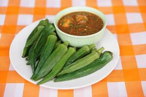 Boiled green okra or lady's finger fruits and chilli paste. Concept healthy food. Delicious menu and good for health with medicinal herbal qualification from local organic fruit and vegetables. photo