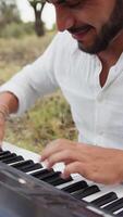 Cheerful Musician Man Strums The Keyboard Sitting On The Grass During A Picnic video