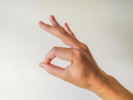 Closeup of a hand forming an OK sign against a plain white background. Perfect for illustrating agreement, approval, or positive concepts. Ideal for websites, presentations, or social media. photo