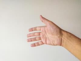 Closeup of a mans hand reaching out, palm up, against a neutral background. Ideal for concepts of help, giving, receiving, connection, or generosity. photo