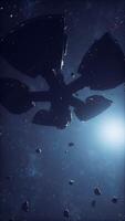 A massive spaceship navigates through a field of asteroids in deep space video