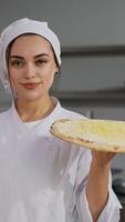 Smiling chef presenting uncooked cheese pizza in kitchen video