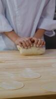Chef kneading dough with prepared flat circles on table video
