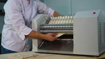 Chef Removing Flattened Dough from Sheeter Machine video