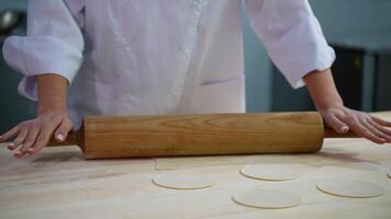 Rolling dough with a wooden rolling pin close-up video
