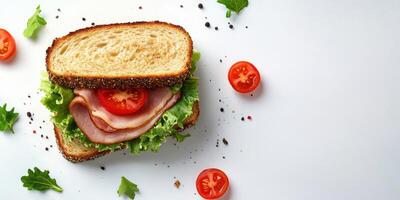 Delicious fresh sandwich with ham, lettuce, and tomato on whole grain bread, garnished with cherry tomatoes and herbs photo