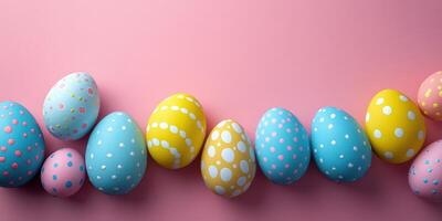 Colorful decorated Easter eggs arranged on a pink background for spring festivities and celebrations photo