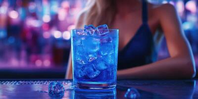 Vibrant blue cocktail served in a glass with ice in a lively bar setting at night photo