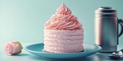 Beautifully decorated pink frosted cake on a blue plate with a silver cup beside it photo