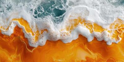 Ocean waves crashing on vibrant orange sandy beach during sunset with white foam splashing photo