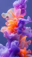 Colorful swirls of purple and orange ink blend gracefully in water, creating an abstract artwork photo