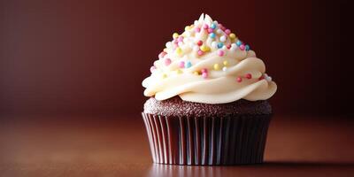 Delicious chocolate cupcake topped with creamy frosting and colorful sprinkles sitting on a wooden surface in a warm setting photo