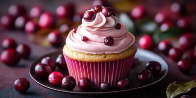 Delicious cranberry cupcake with pink frosting presented on a dark plate surrounded by fresh cranberries photo