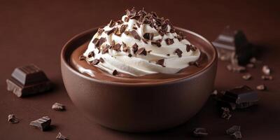 Indulgent chocolate mousse with whipped cream and chocolate shavings garnished in a dark bowl photo