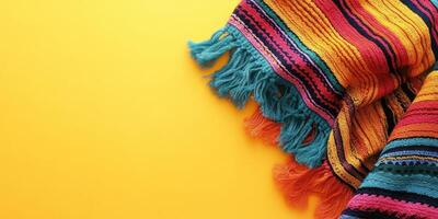 Colorful Mexican blanket draped on bright yellow background showcasing intricate patterns and vibrant hues photo