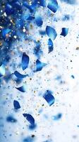 Colorful blue confetti and glitter falling against a light background during a celebration or festivity photo