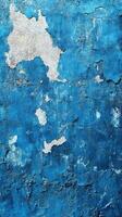 Textured blue wall with peeling paint revealing layers underneath in an urban setting photo