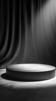 Circular platform illuminated by soft light with dark curtains in a minimalist setting during an artistic event photo